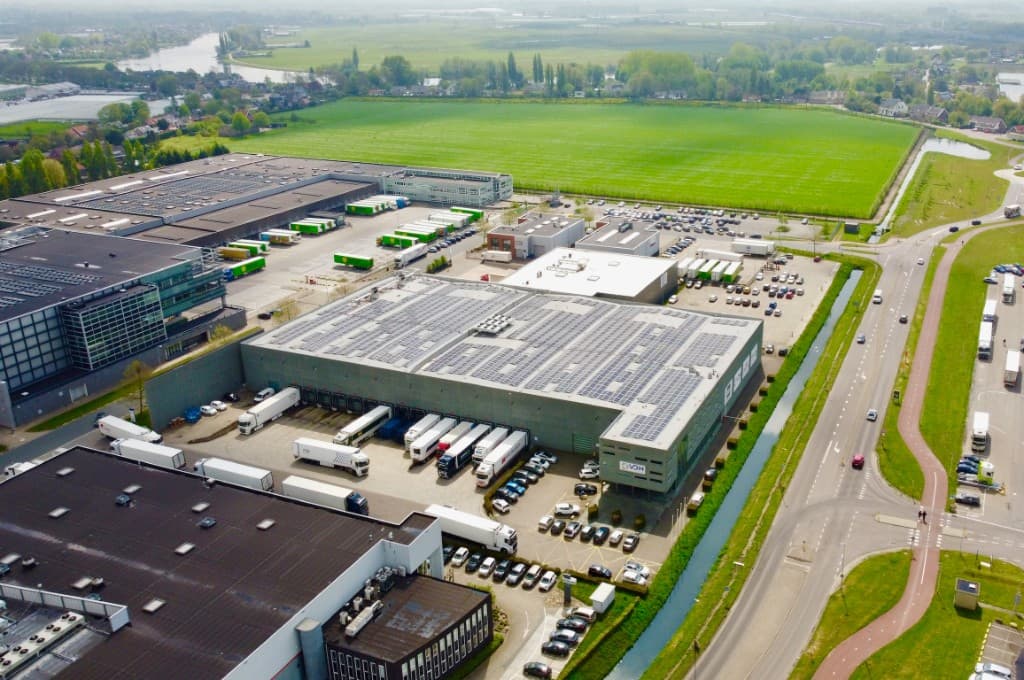 Luchtfoto van een industrieel pand met zonnepanelen op het dak in Pernis